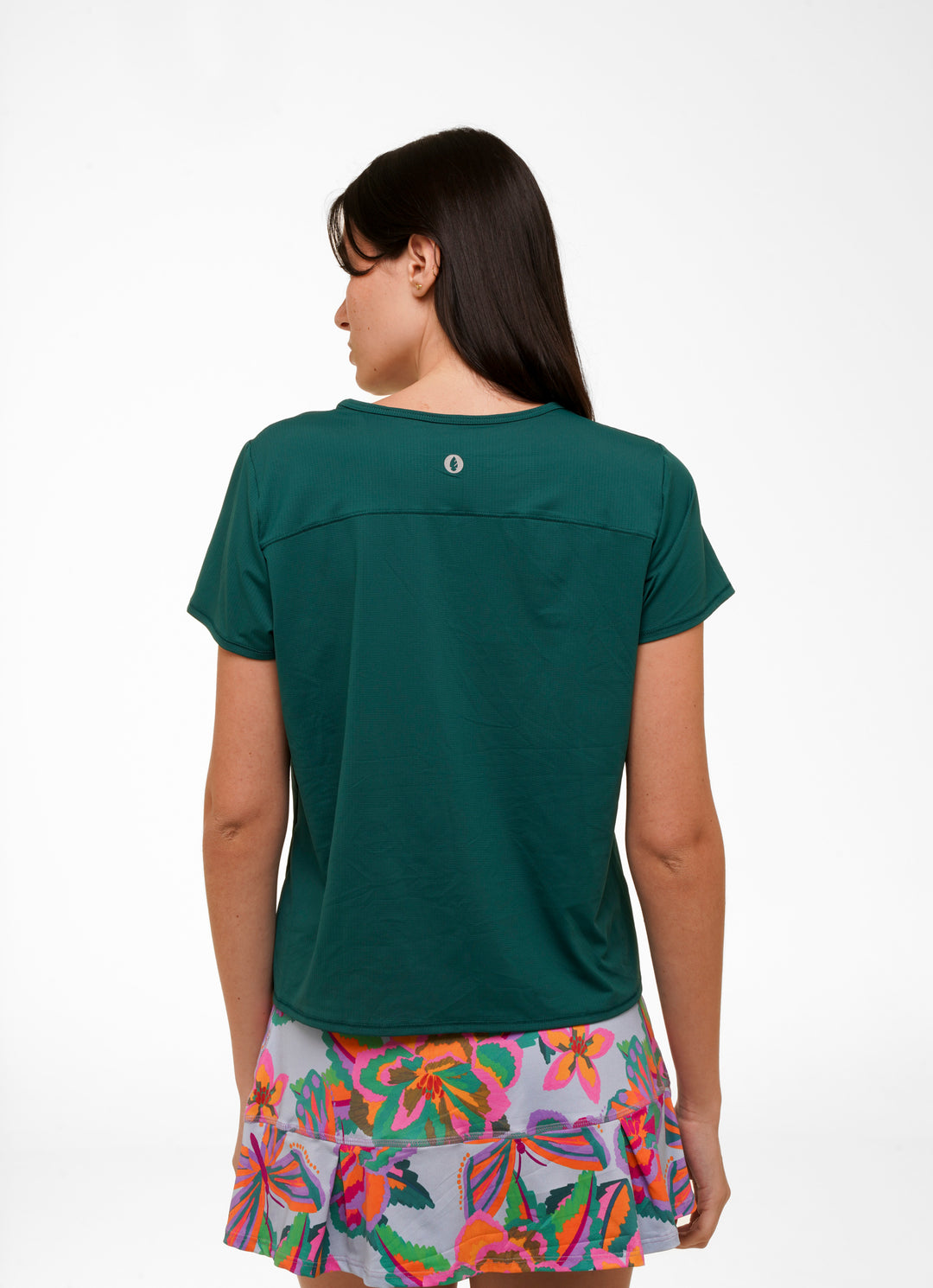 Woman wearing a green t-shirt and colorful skirt on a white background